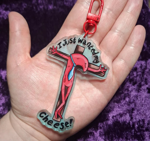 Keychain with cartoon character and text held in a hand against a purple background